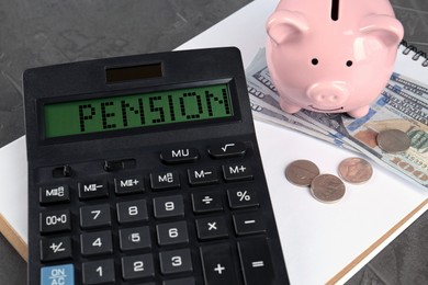 Image of Calculator with word Pension, piggy bank, money and notebook on grey table, closeup