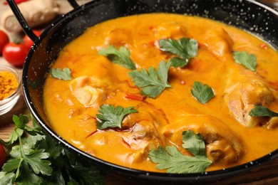 Tasty chicken curry with parsley on table, closeup