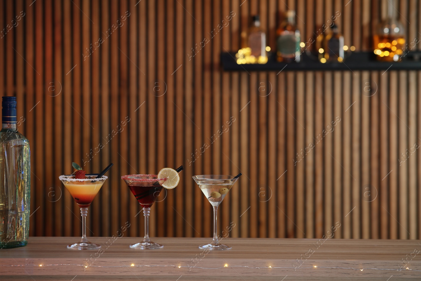 Photo of Different martini cocktails on table in bar, space for text