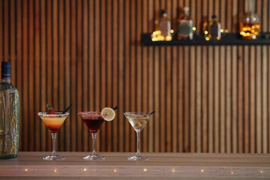 Photo of Different martini cocktails on table in bar, space for text