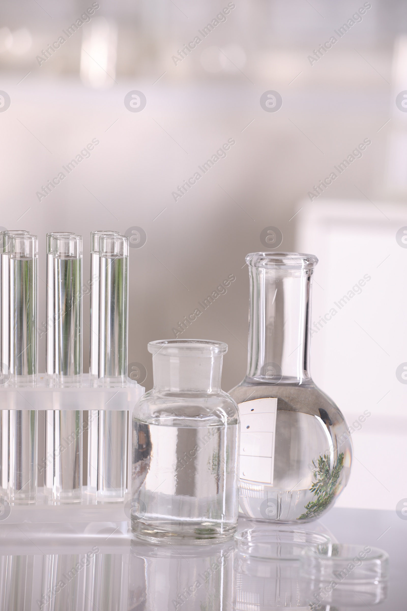 Photo of Laboratory analysis. Different glassware with liquid on white table indoors