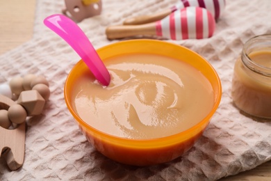 Photo of Healthy baby food in bowl on table, closeup