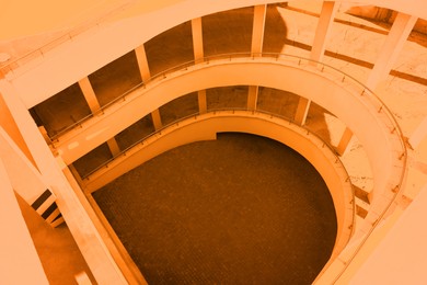 Image of Open car parking garage with ramp, above view. Toned in orange