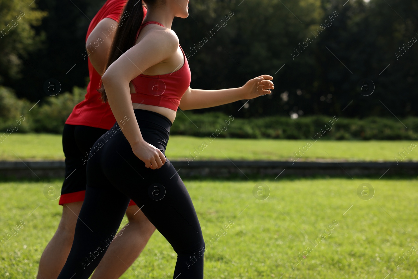 Photo of Healthy lifestyle. Couple running in park on sunny day, closeup