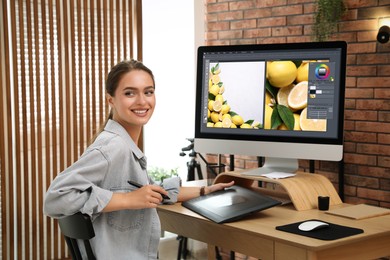 Photo of Professional retoucher working on graphic tablet at desk in office