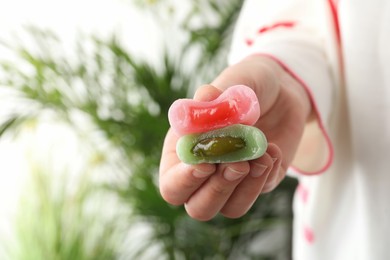 Woman holding different delicious mochi, closeup. Space for text