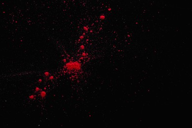 Red powder dye on dark background, top view with space for text. Holi festival