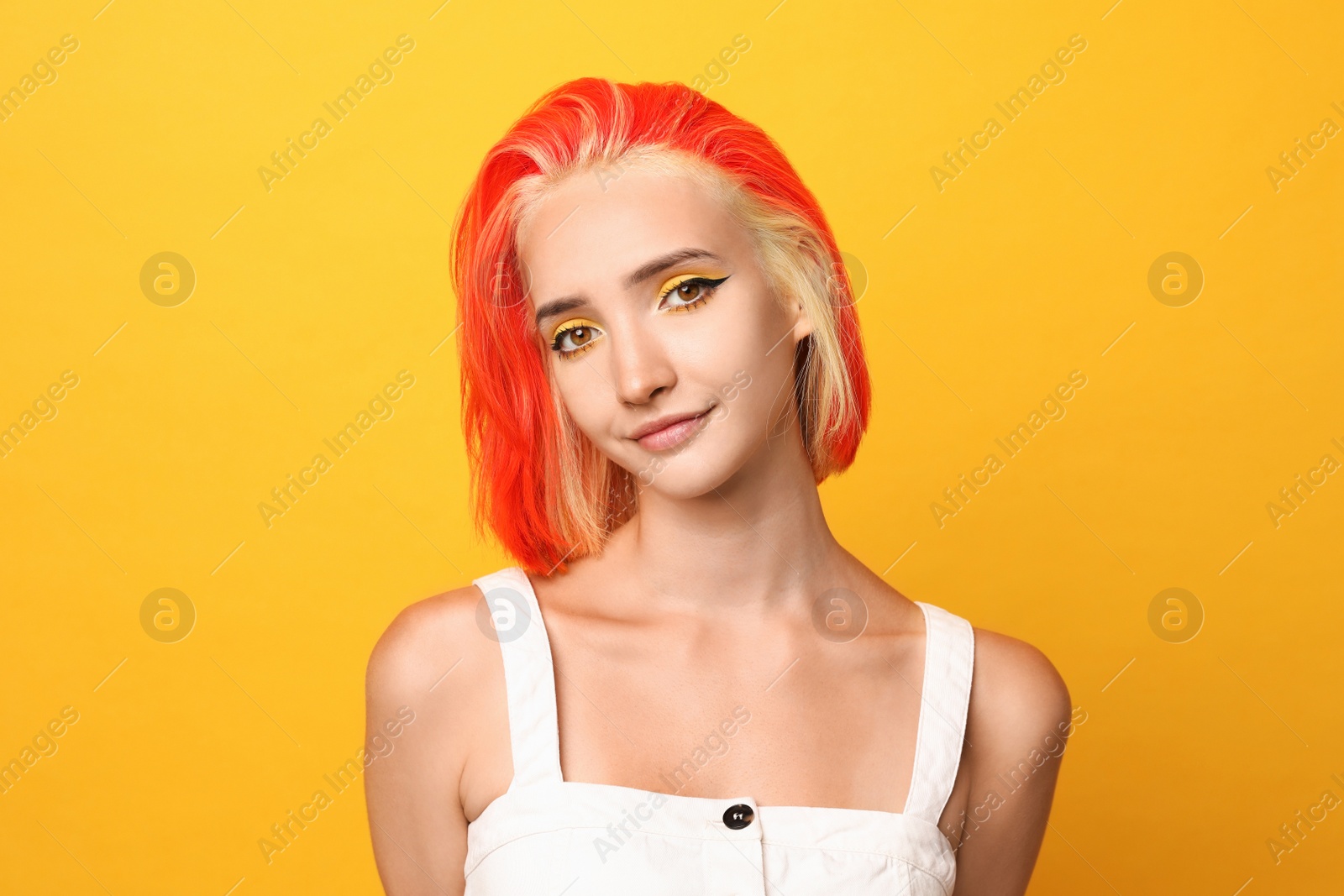 Photo of Beautiful young woman with bright dyed hair on orange background