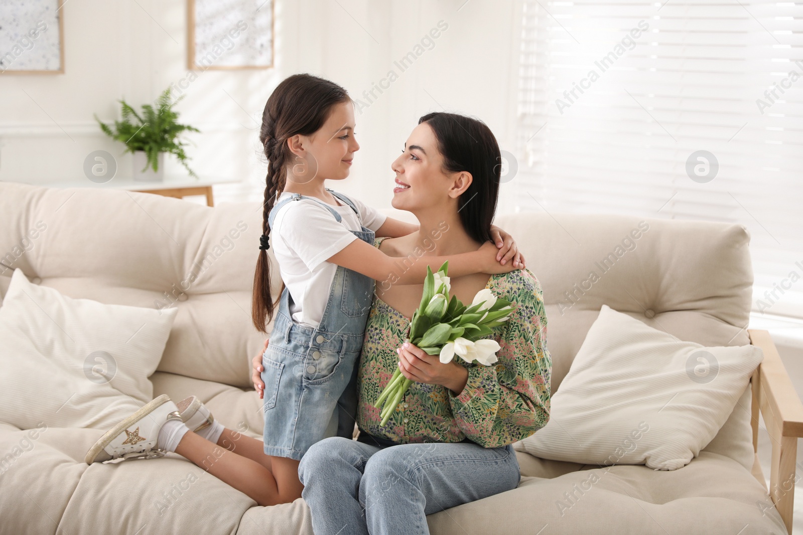 Photo of Little daughter congratulating her mom at home. Happy Mother's Day