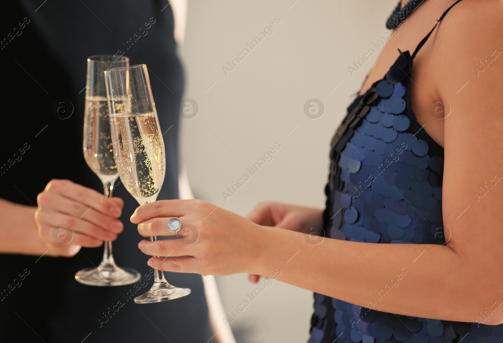 Photo of Friends clinking glasses with champagne at party indoors, closeup