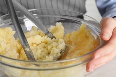 Photo of Woman making mashed potato at table, closeup