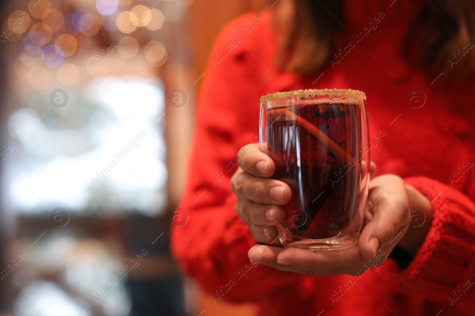 Photo of Woman with tasty mulled wine indoors, closeup