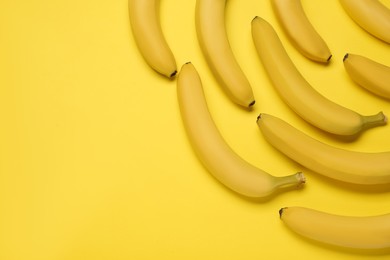 Ripe sweet bananas on yellow background, flat lay. Space for text