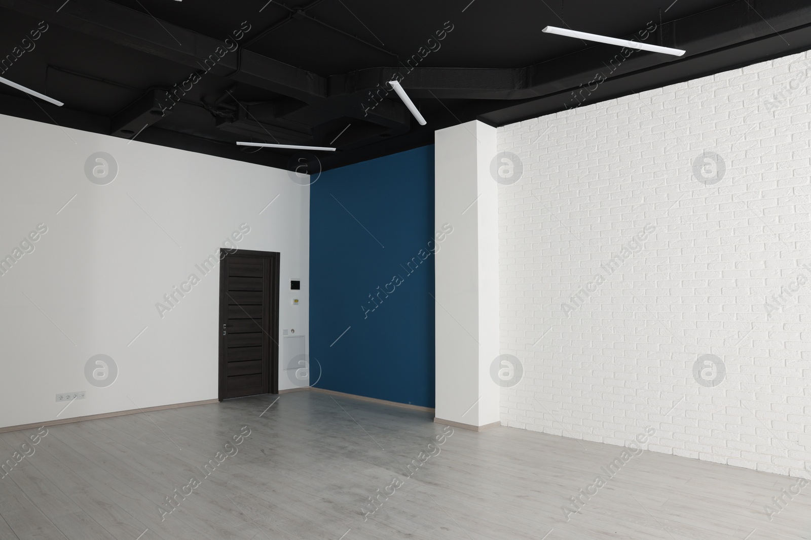 Photo of Empty office room with black ceiling and door. Interior design