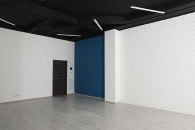 Photo of Empty office room with black ceiling and door. Interior design