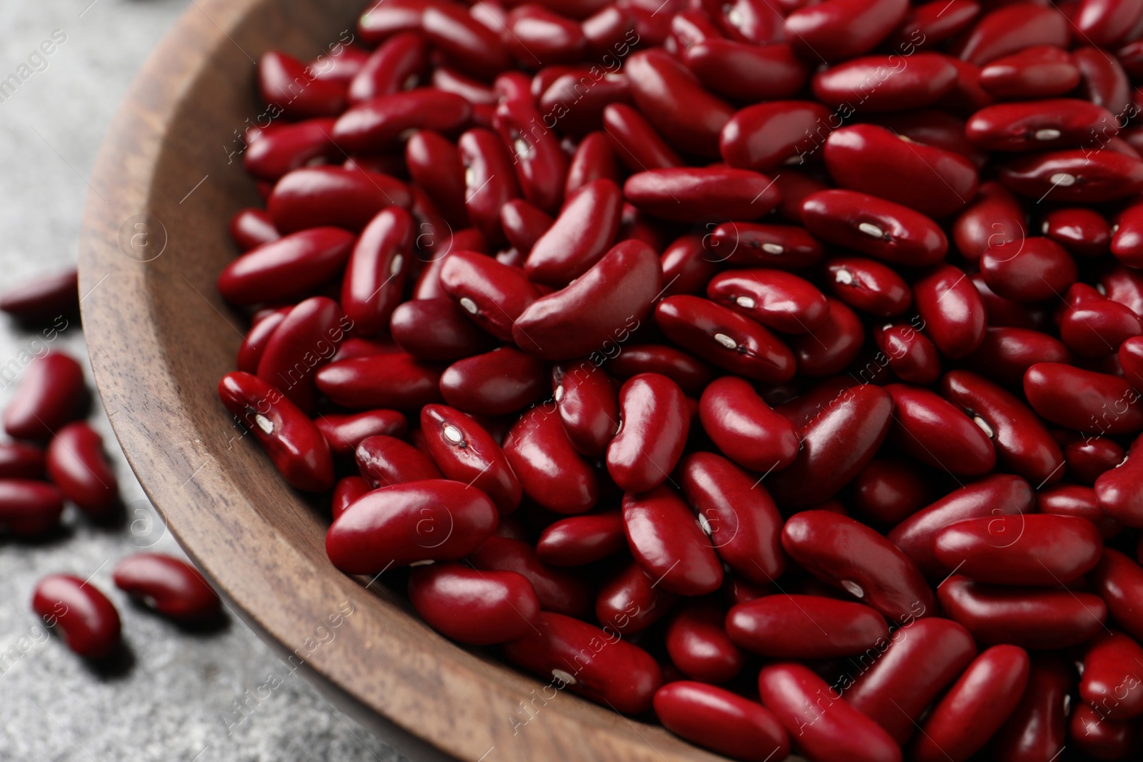 Photo of Raw red kidney beans in wooden bowl, closeup