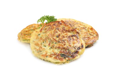 Delicious zucchini fritters with curly parsley on white background