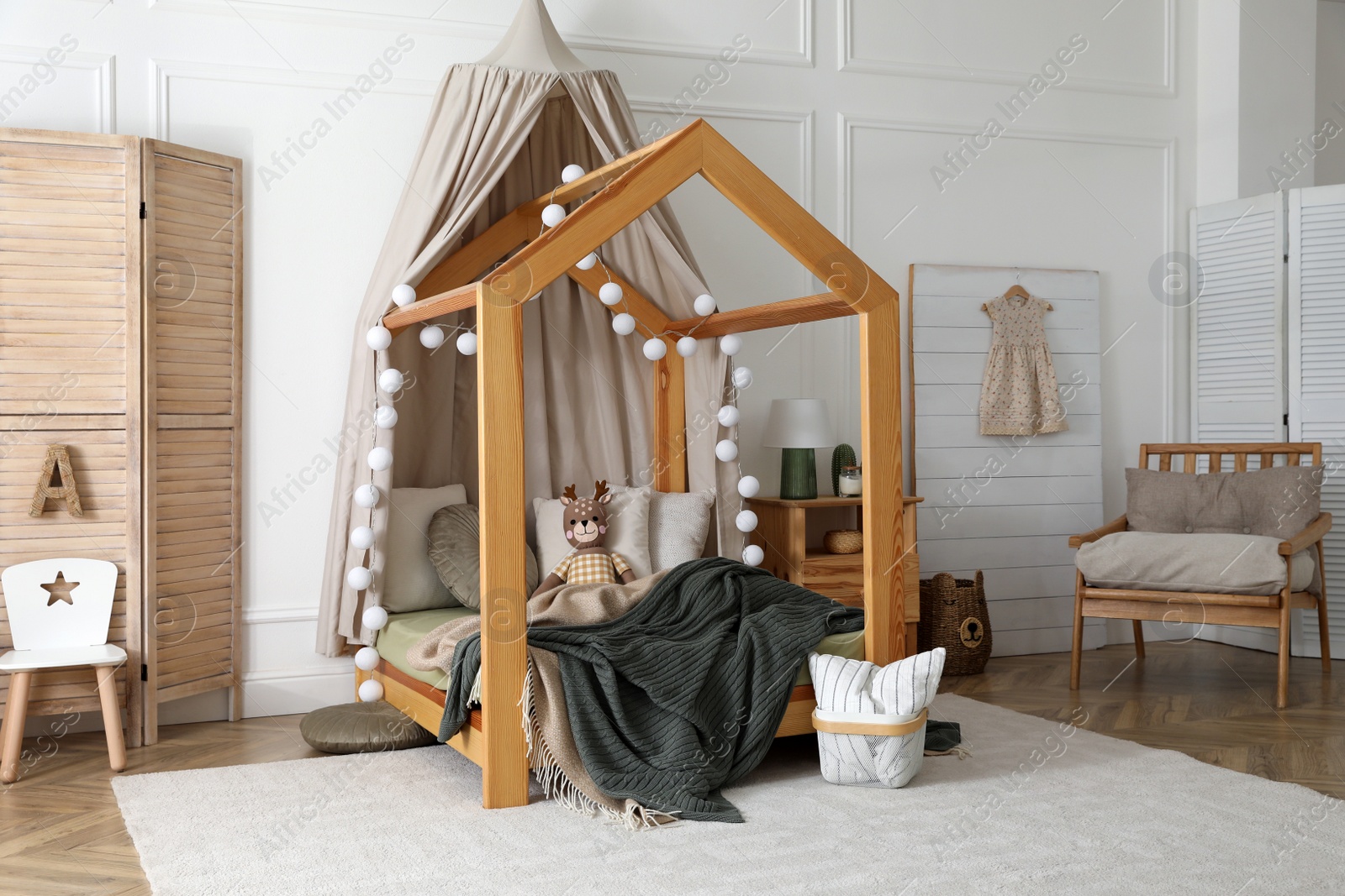 Photo of Stylish child room interior with wooden house bed