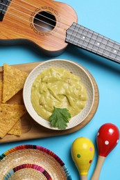 Flat lay composition with Mexican sombrero hat and guacamole on light blue background