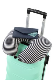 Photo of Soft travel pillow and purse on turquoise suitcase isolated on white