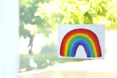 Photo of Picture of rainbow on window glass indoors. Stay at home concept