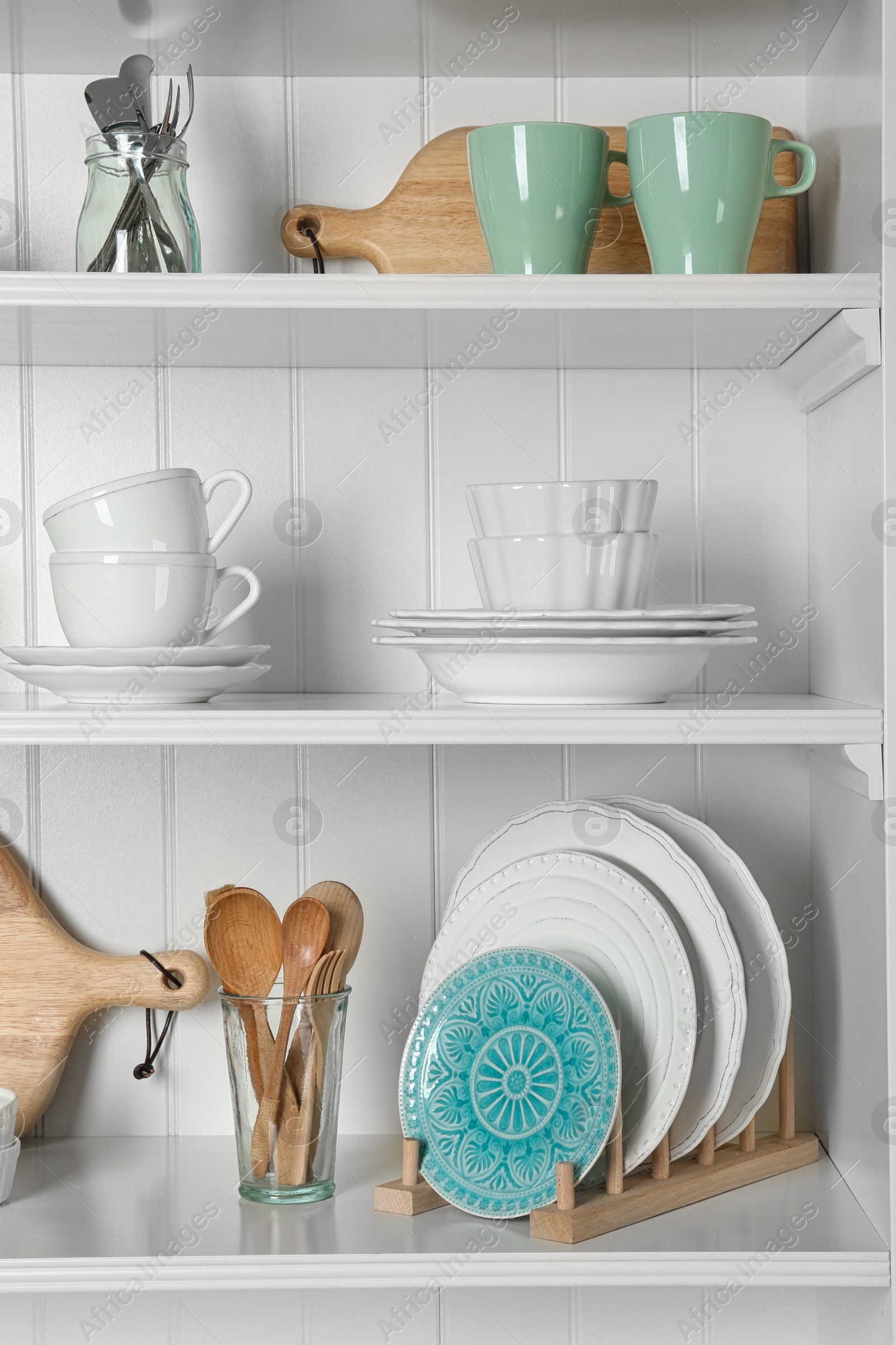 Photo of White shelving unit with set of dishware