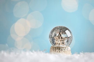 Photo of Beautiful snow globe with stars against blurred Christmas lights. Space for text