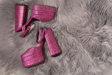 Photo of New pink high heeled shoes with platform and square toes on grey fur, flat lay. Space for text