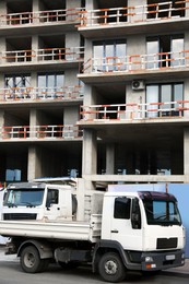 Construction site with unfinished building and trucks outdoors