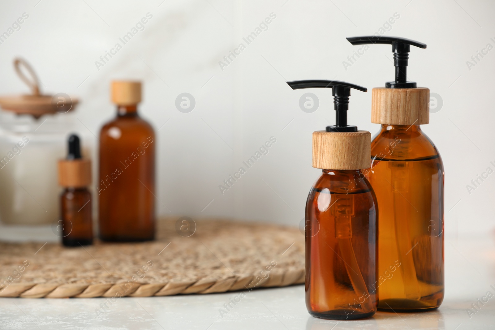 Photo of Bottles with dispenser caps on white table, closeup. Space for text