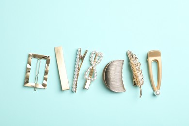 Photo of Stylish hair clips on light blue background, flat lay