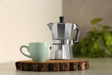 Photo of Ceramic cup and moka pot on light countertop in kitchen