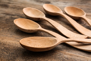 Photo of Clean empty spoons on wooden background, closeup