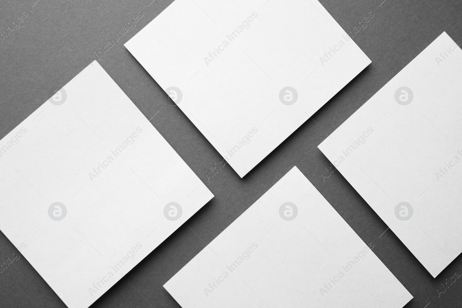 Photo of Blank note papers on dark grey background, flat lay. Mock up for design