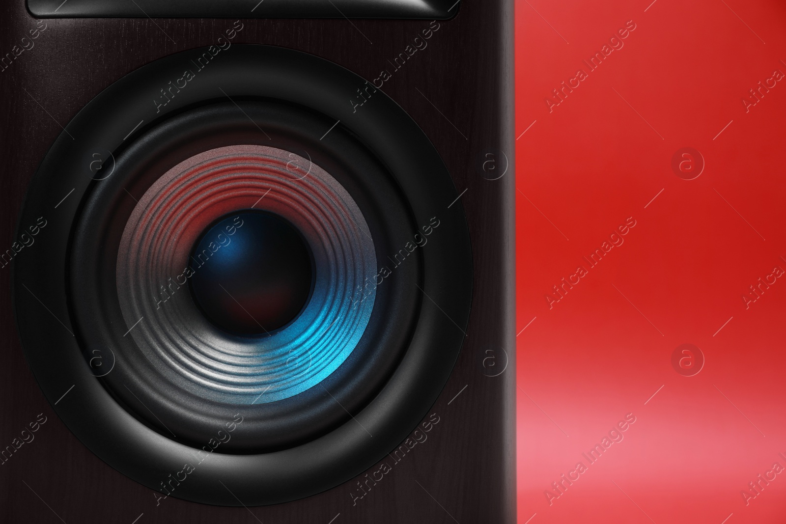 Photo of One wooden sound speaker on red background, closeup. Space for text