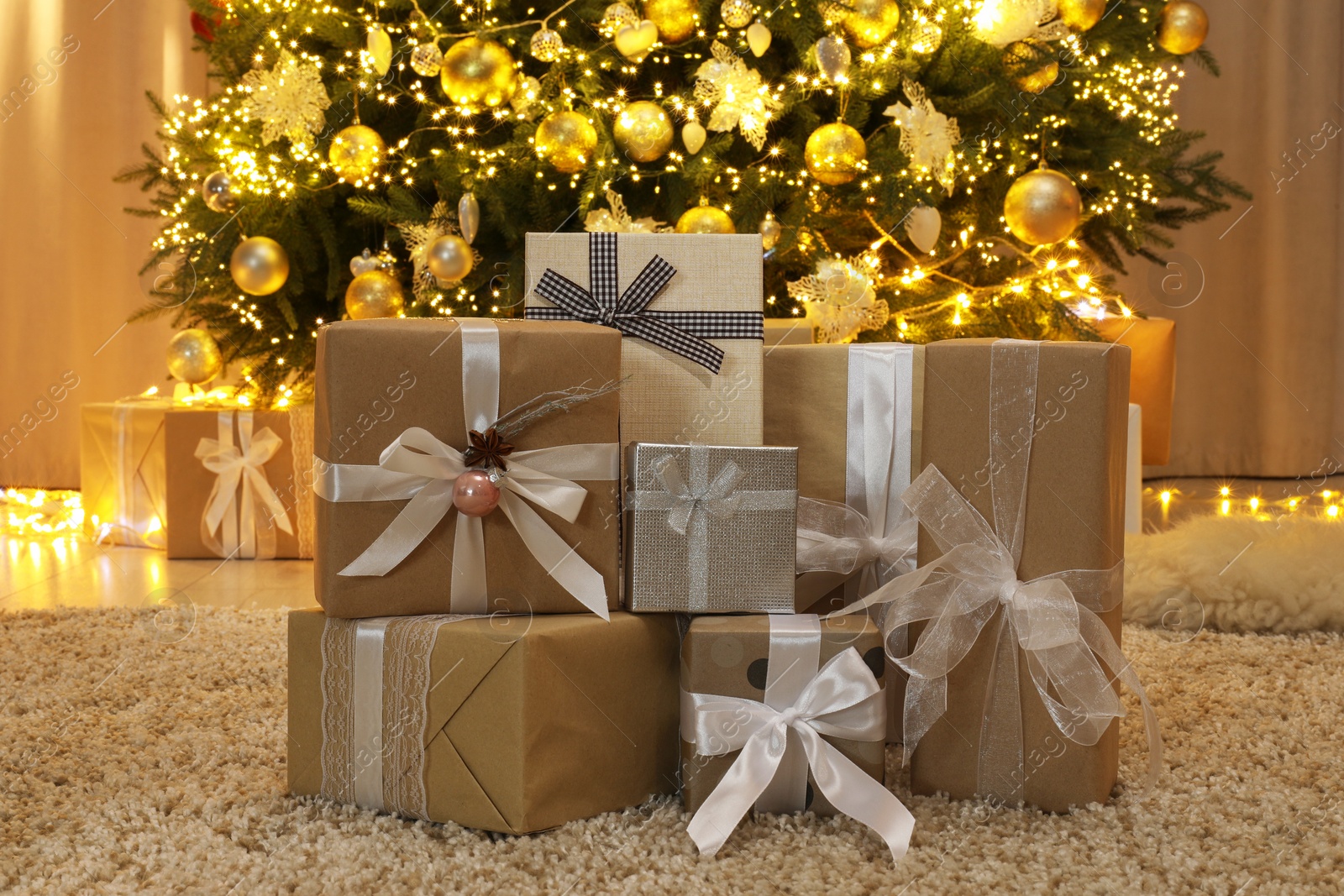 Photo of Many gift boxes near decorated Christmas tree at home