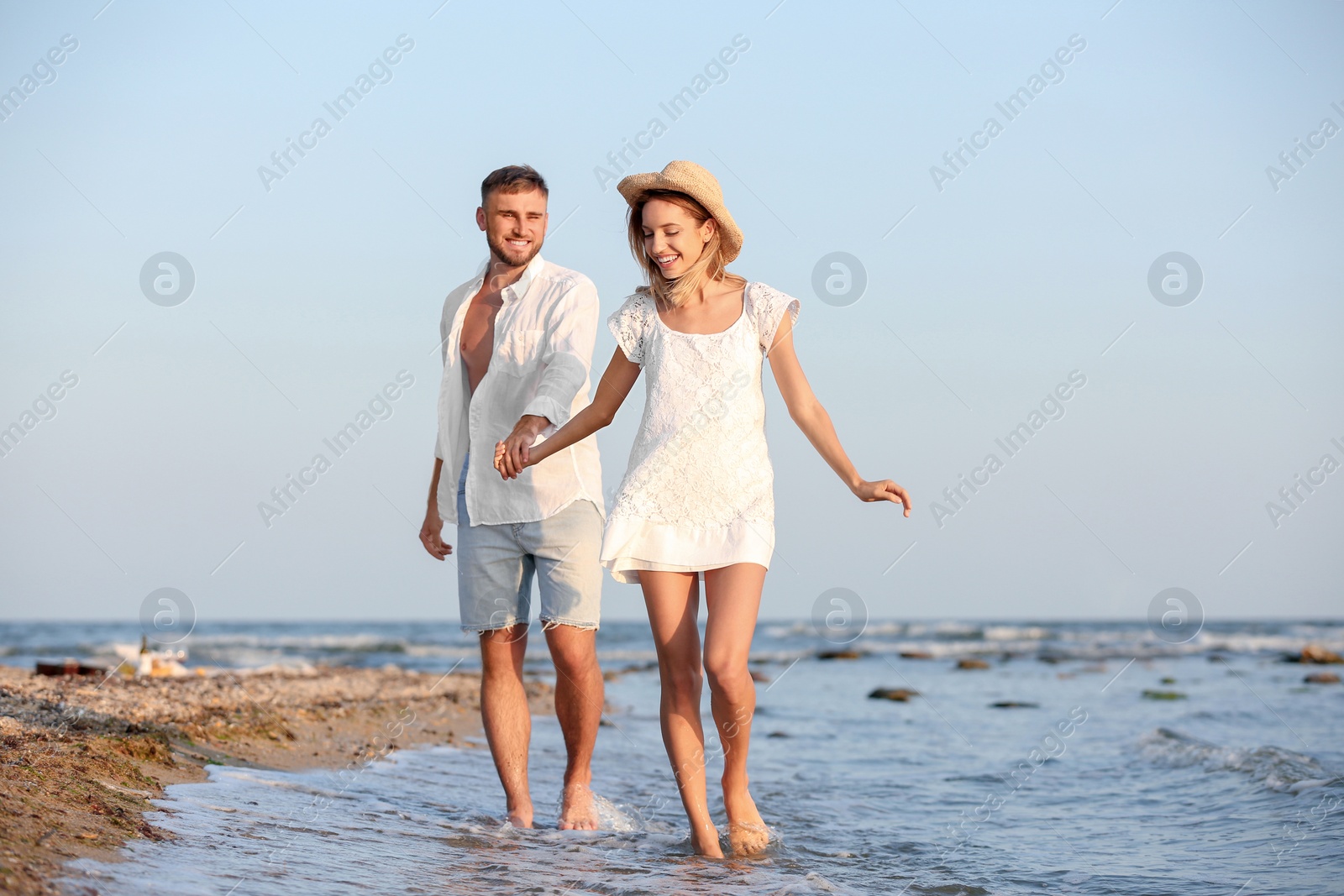 Photo of Young couple spending time together on beach