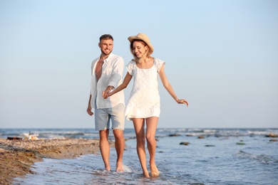 Photo of Young couple spending time together on beach