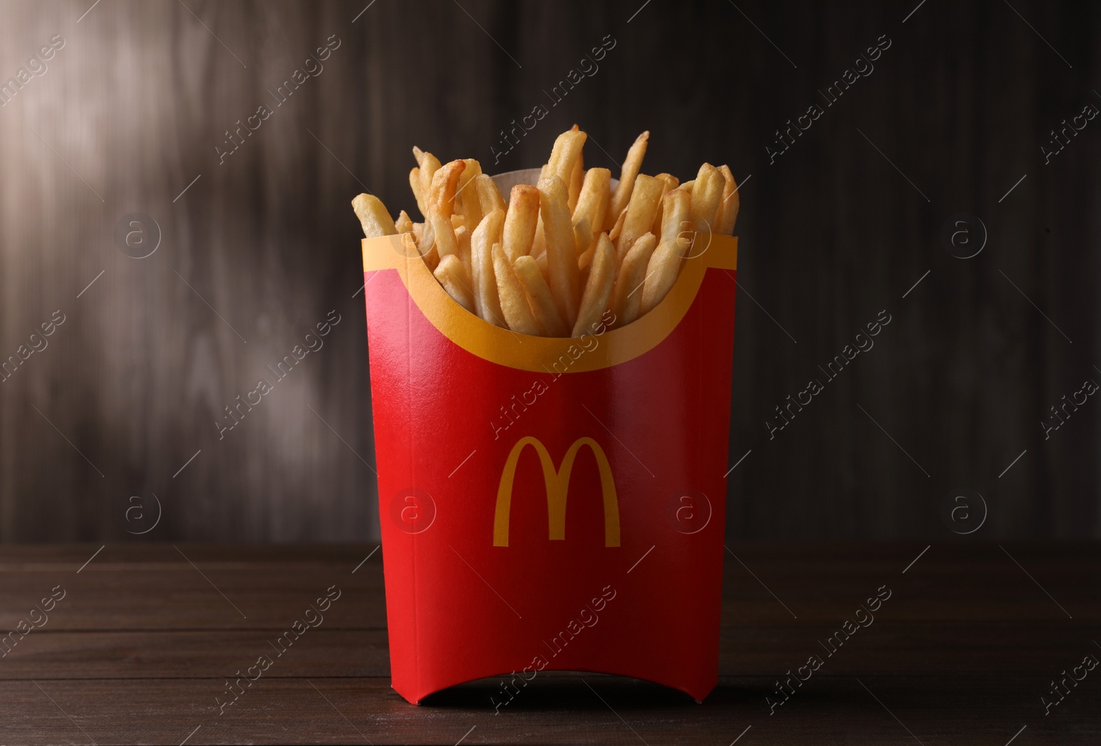 Photo of MYKOLAIV, UKRAINE - AUGUST 12, 2021: Big portion of McDonald's French fries on wooden table