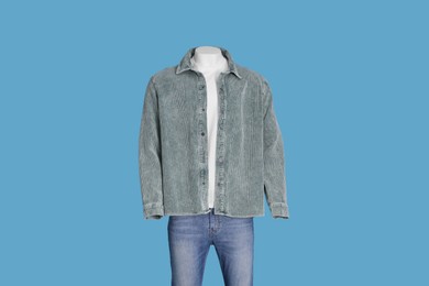 Male mannequin dressed in white t-shirt, jeans and stylish jacket on light blue background