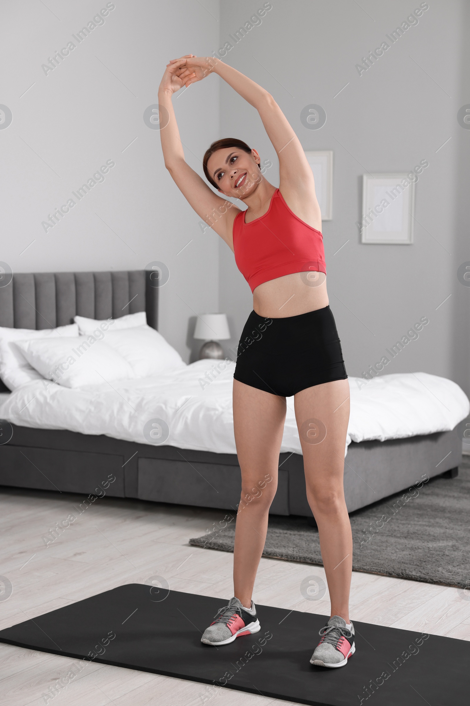 Photo of Morning routine. Happy woman stretching at home