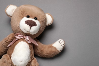 Photo of Cute teddy bear on gray background, top view. Space for text