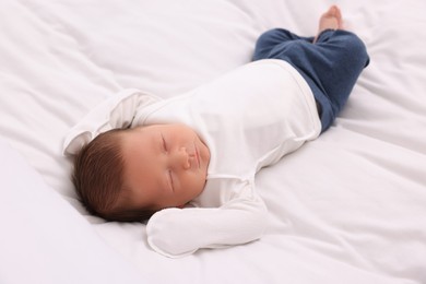 Cute newborn baby sleeping on white soft bed