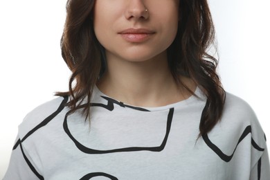 Young woman with nose piercing on white background, closeup