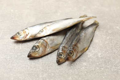 Photo of Fresh raw sprats on grey table, closeup