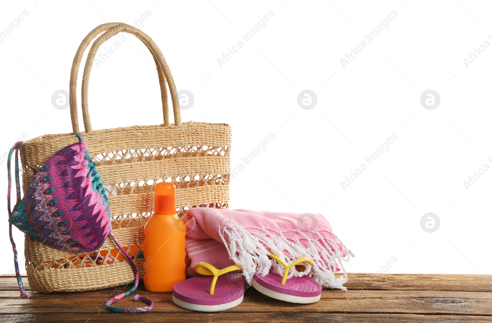 Photo of Stylish bag with beach accessories on wooden table. Space for text