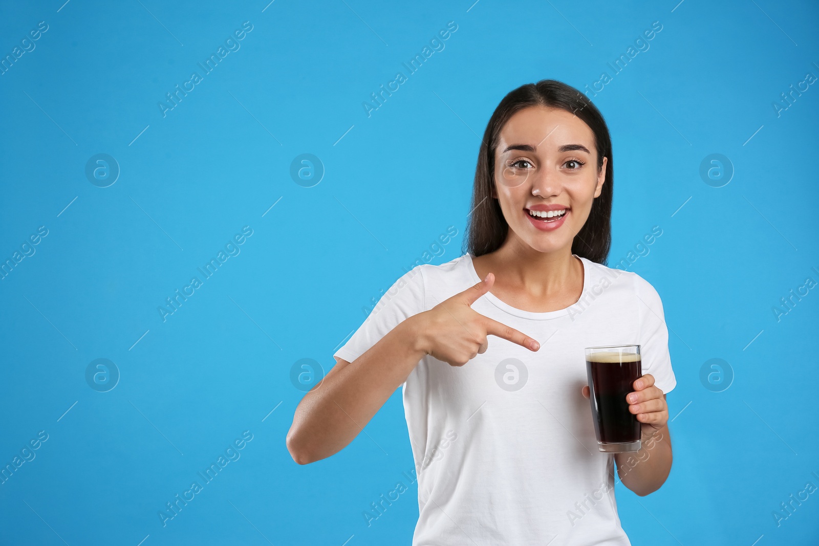 Photo of Beautiful woman with cold kvass on blue background. Traditional Russian summer drink