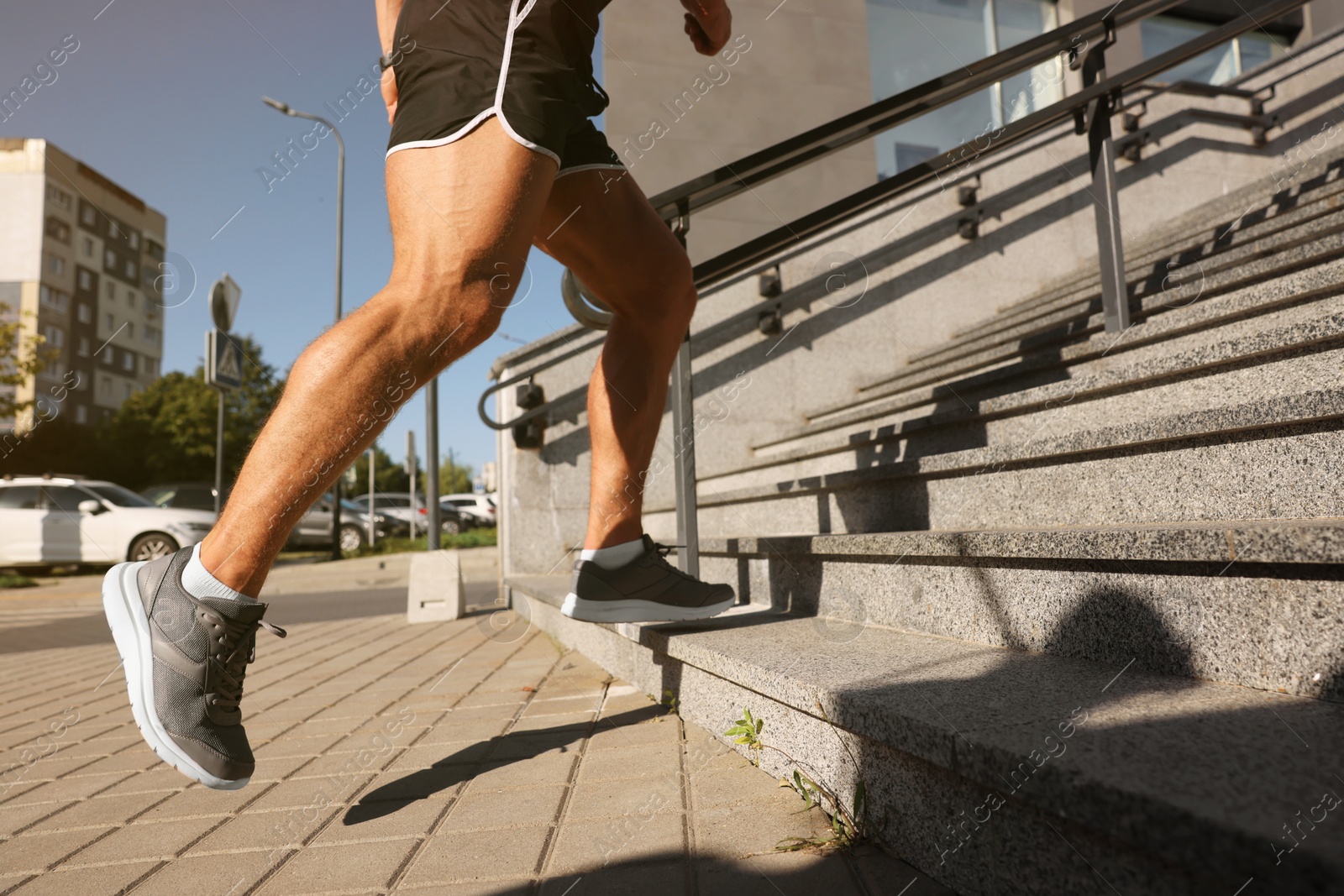 Photo of Man running up stairs outdoors on sunny day, closeup. Space for text