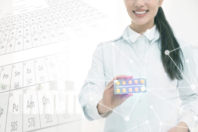 Image of Professional pharmacist with pills and periodic table, closeup