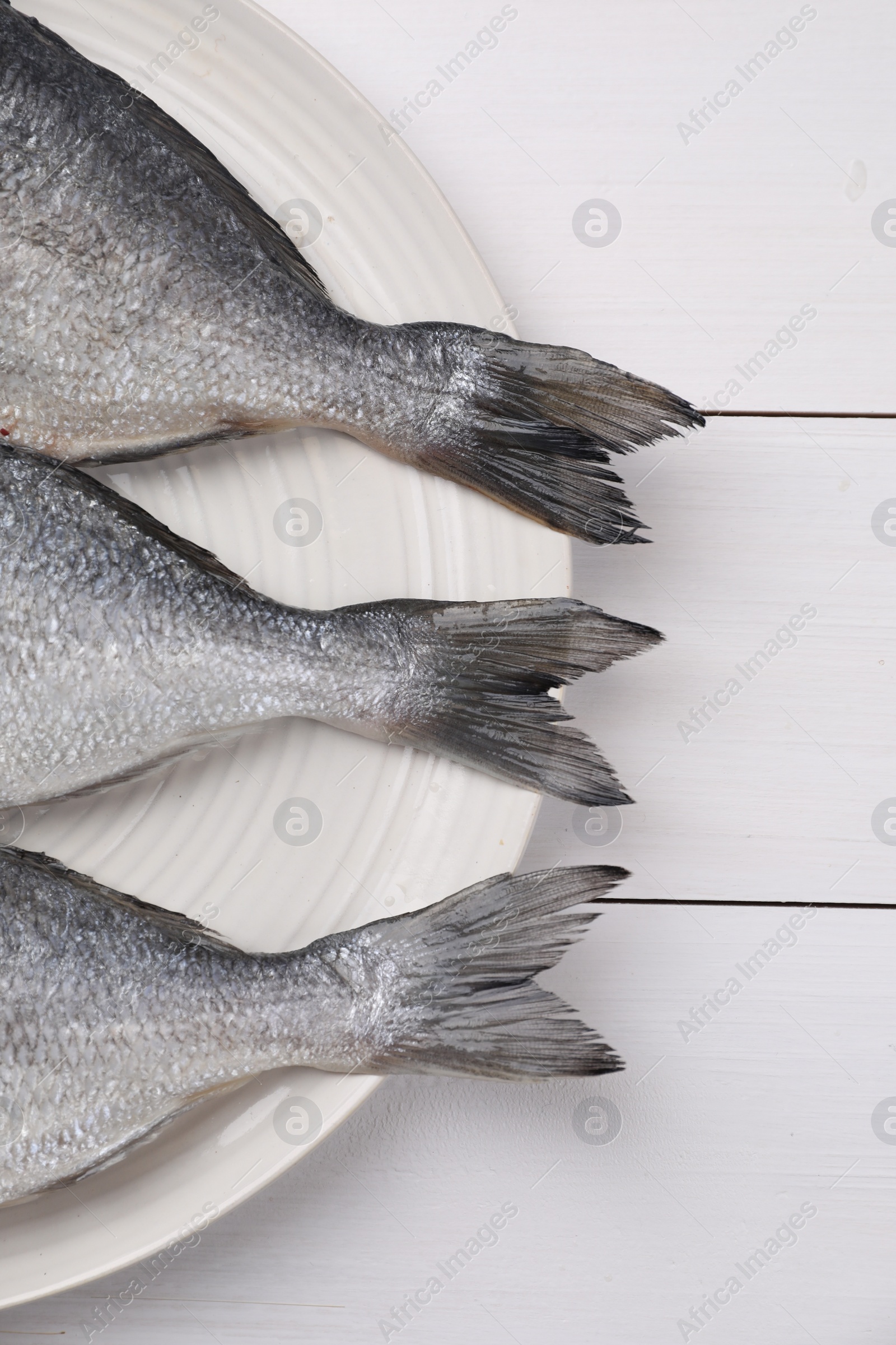 Photo of Fresh raw dorado fish on white wooden table, top view